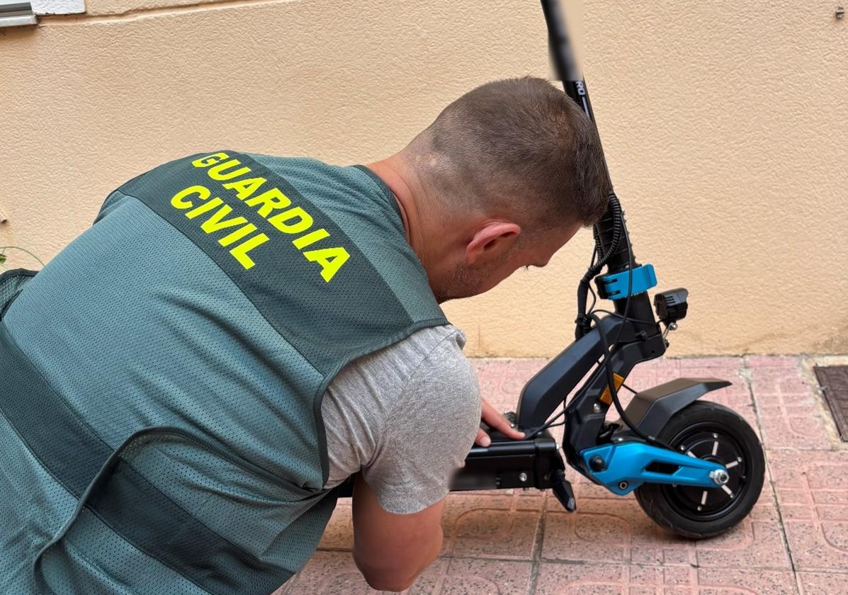 Uno de los agentes que han participado en la operación, junto al patinete recuperado en Dolores.