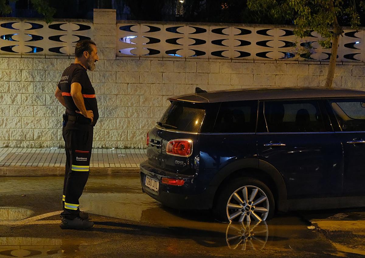 Imagen secundaria 1 - 1. Un bombero comprueba la profundidad del socavón. 2. Tratan de sacar el vehículo atascado. 3. Restos en la calle de las aguas fecales.