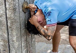 Una persona se refresca en una fuente.