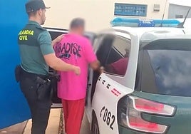 Uno de los detenidos, custodiado por la Guardia Civil.