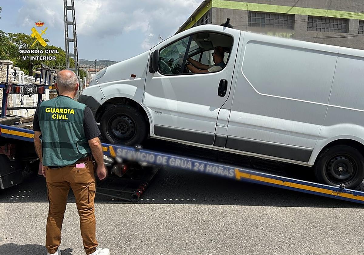 Dos agentes decomisan una de las furgonetas que el apresado albergaba en un taller de Ibi.