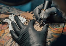 Artista realizando un tatuaje.