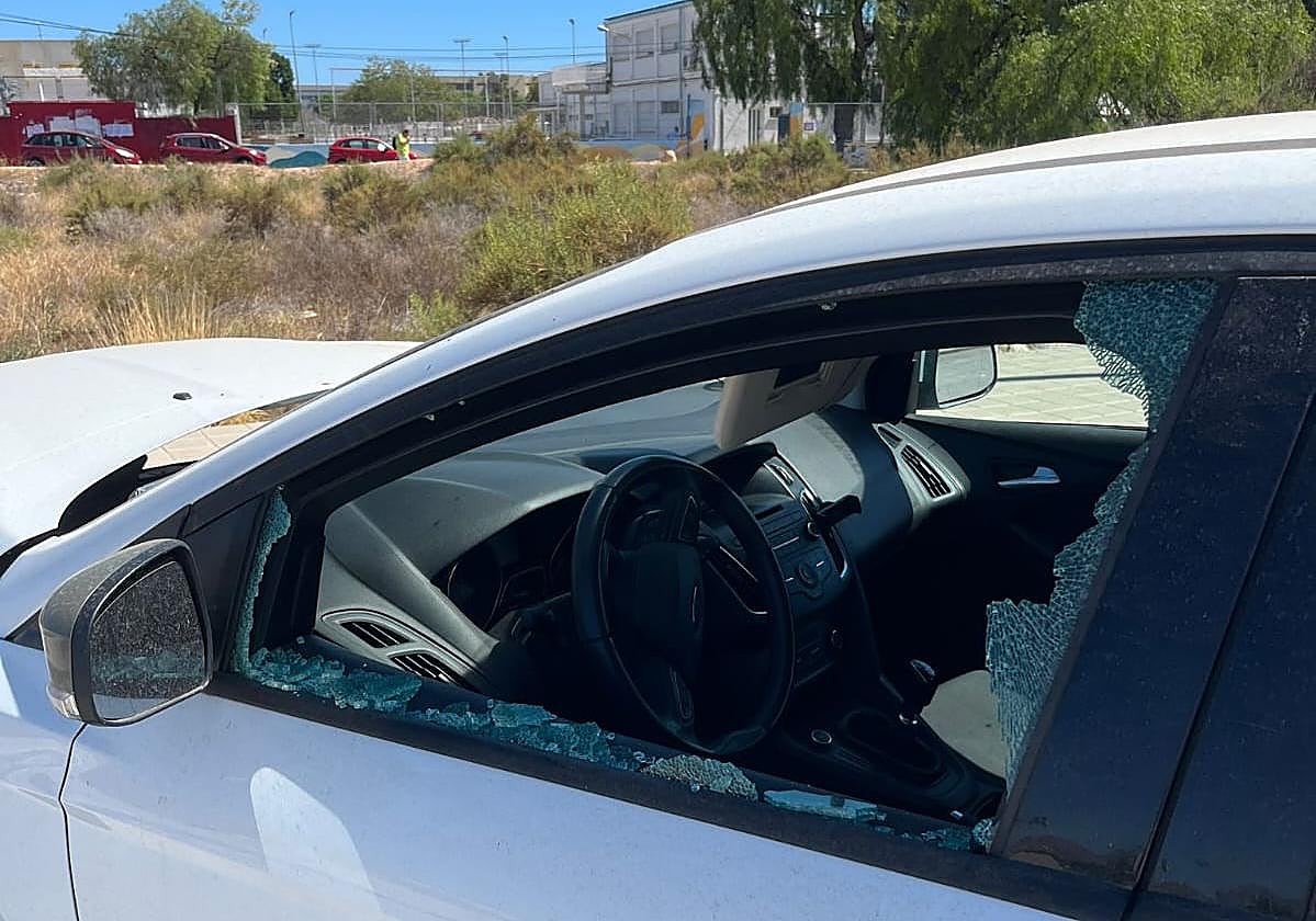 La ventanilla de uno de los coches estacionados frente al centro, destrozada.