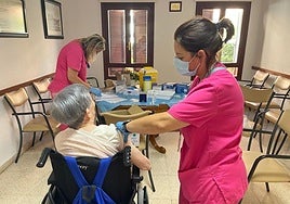 Enfermeras vacunan a una persona mayor, grupo de riesgo.