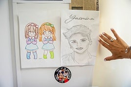 Yasmina muestra un retrato hecho por 'sus niños' del centro de menores y un dibujo. Debajo, una pegatina: 'Esto no es Disneyland'.