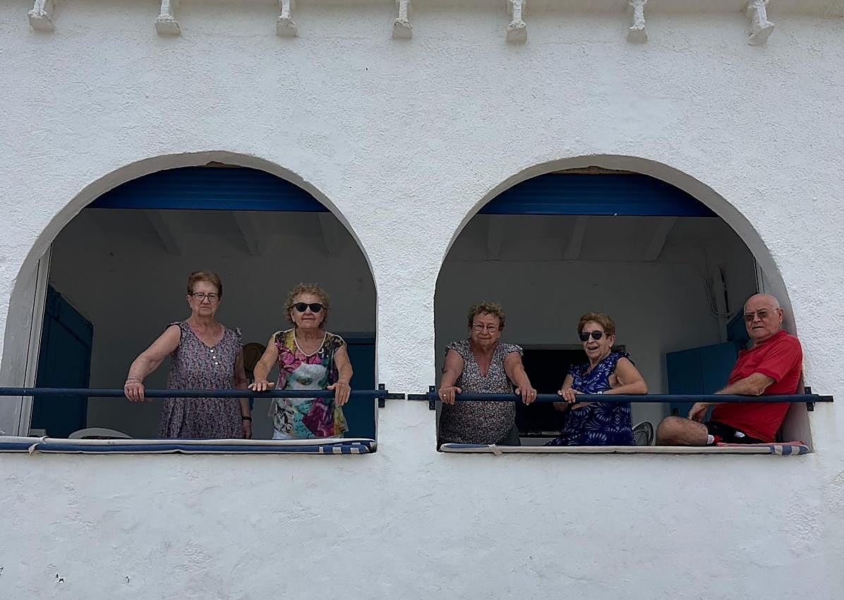 Imagen secundaria 1 - La casa con la puerta abierta y algunos de los dueños, de Gata, posando en la escaleras más virales de España.