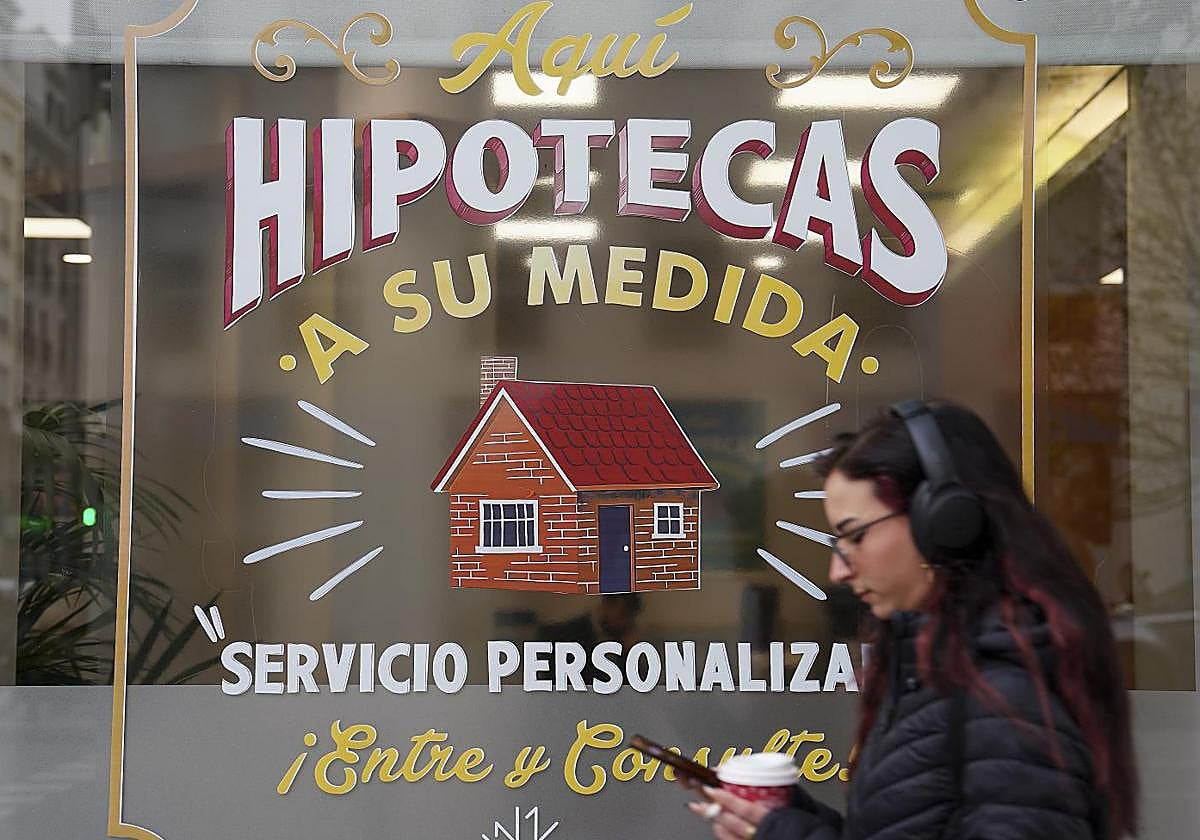 Una joven pasa por delante de una sucursal que oferta hipotecas.