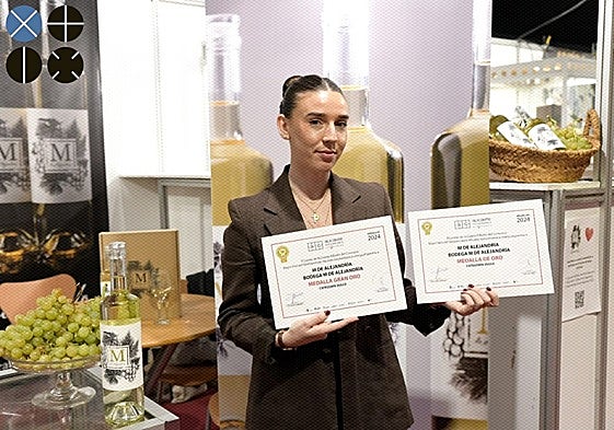 Cristina Tro, segunda generacción de la bodega, muestra los diplomas que acreditan a 'M de Alejandría' con las medallas de oro y gran oro en Alicante Gastronómica.
