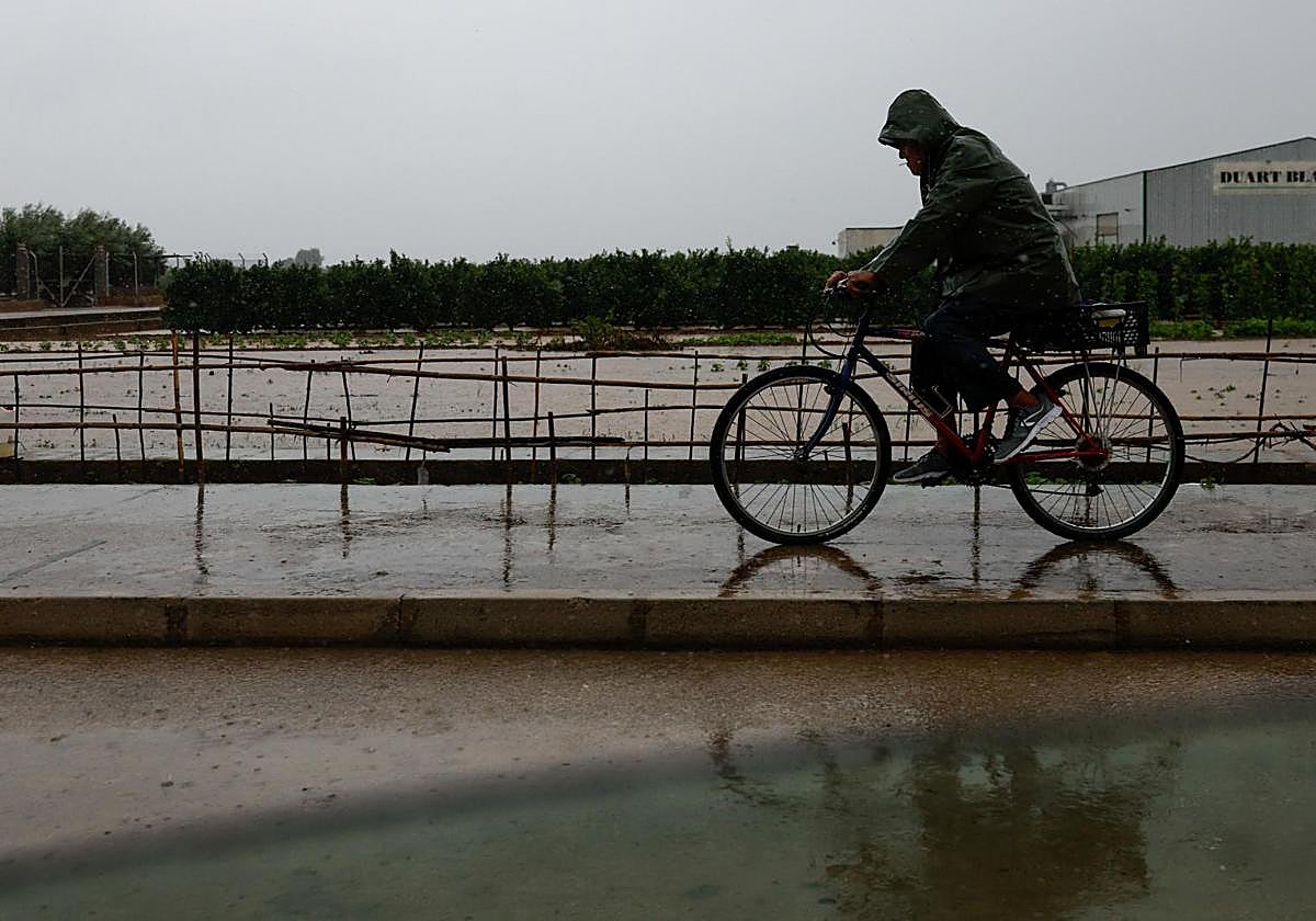 A man on a bicycle during the rainy days caused by storm 'Alice'.