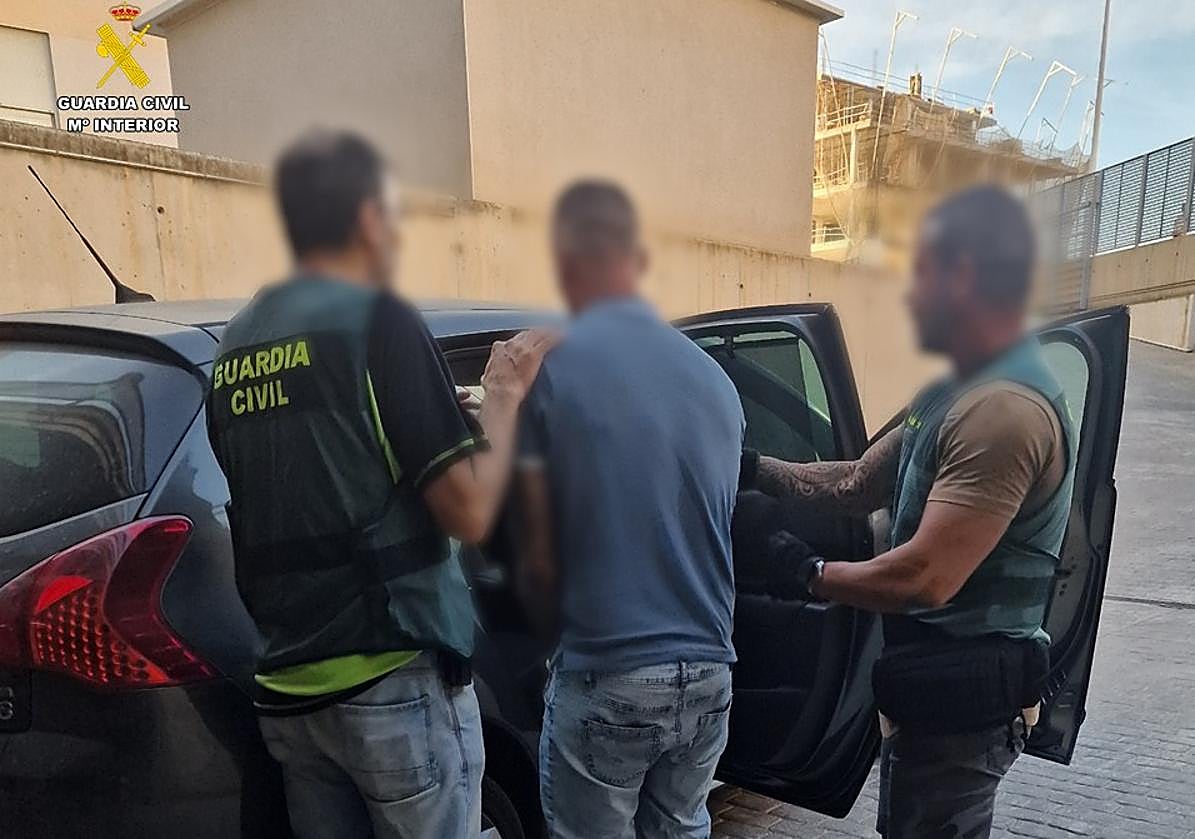 Agentes de la Guardia Civil custodian al detenido como presunto autor del disparo.