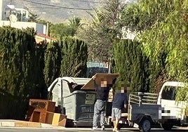 Dos personas tiran escombros en El Campello.