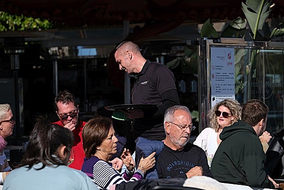 Camarero atendiendo a una mesa en un bar de Alicante.