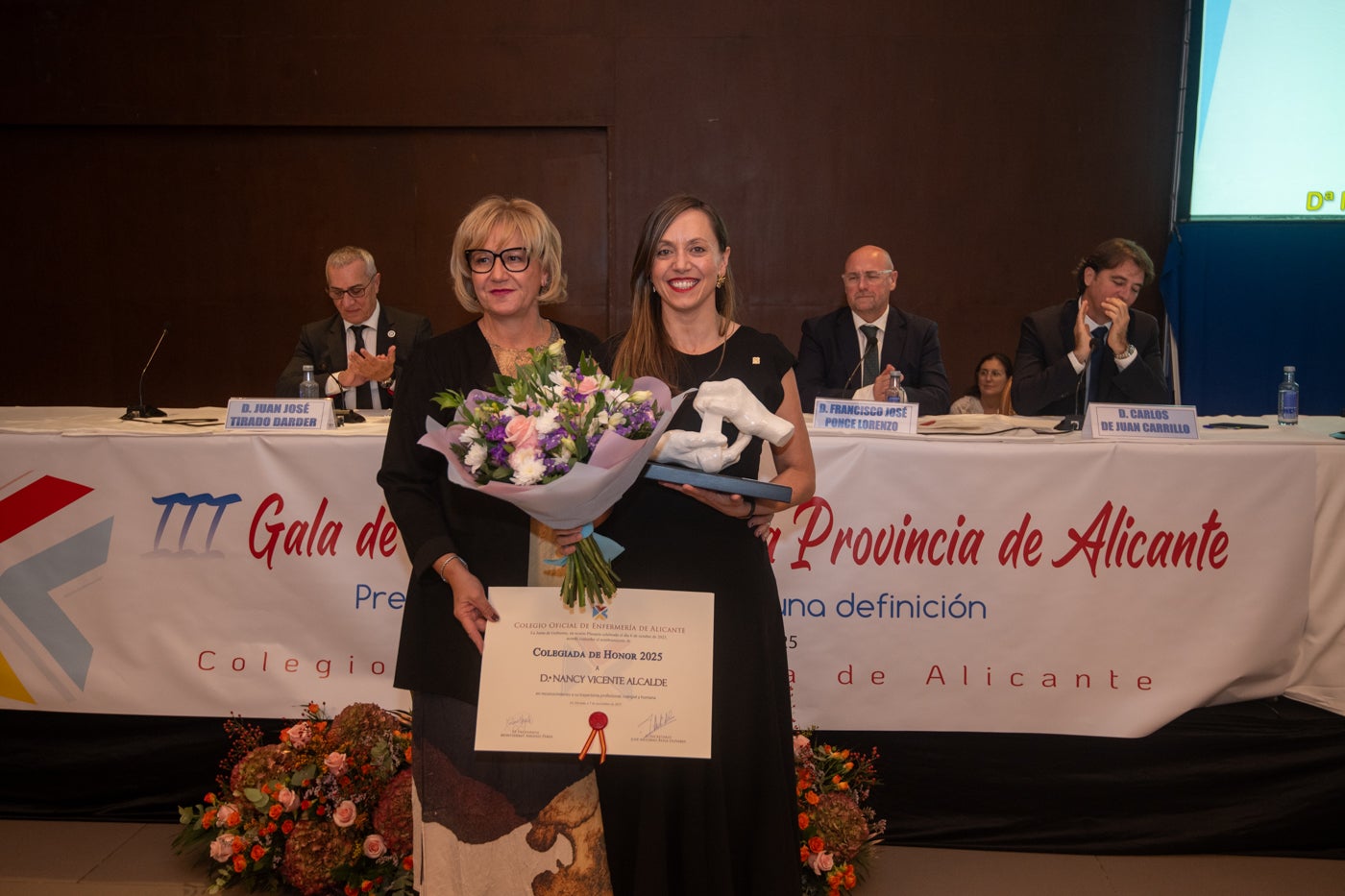 La presidenta del Colegio de Enfermería, Montserrat Angulo,, con la colegiada de honor 2025, Nancy Vicente Alcalde.