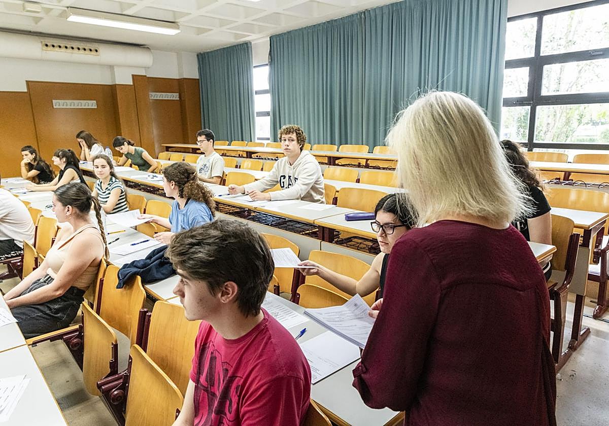 Docente reparte exámenes en un centro educativo de Alicante.