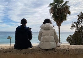 Dos chicas observan la playa del Postiguet.
